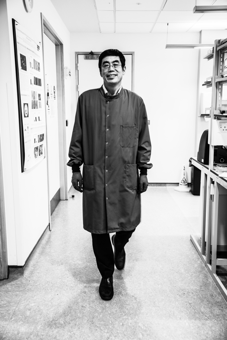 Academic in labcoat smiling and walking