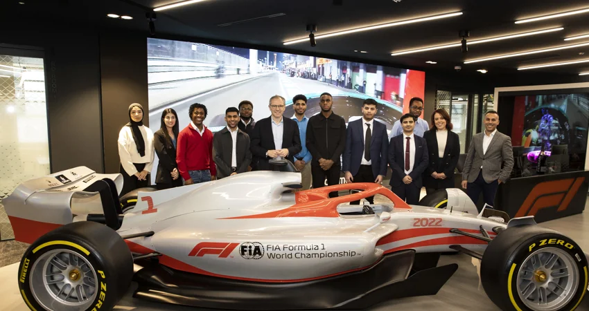 Undergraduates stood behind Formula 1 racing car
